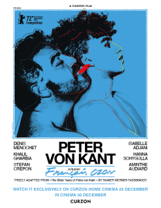 Picture a bearded middle aged man and young man lying together in blue and black theres a red tongue pointing out of the middle aged man mouth. Big writing saying Peter Von Kant which is the title of the film.